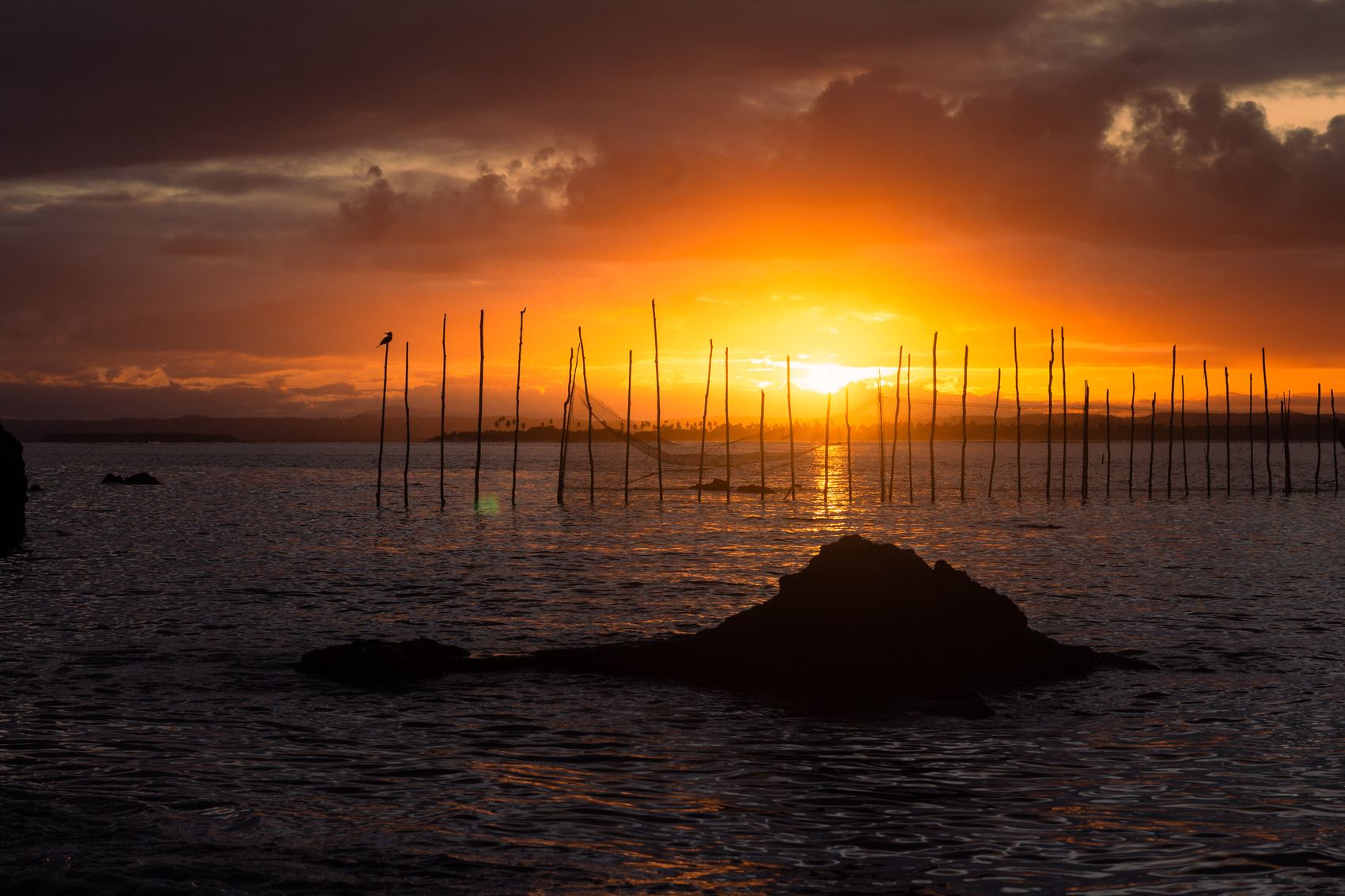 Sol descendo atrás das armações de pesca